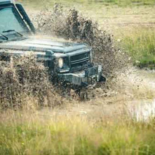 Off road car on mountain road. Offroad travel on mountain road. Mud and water splash in off-road racing